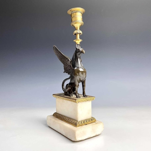 8 - A French bronze and ormolu candlestick, late 19th century, modelled as a winged griffin, on a steppe... 