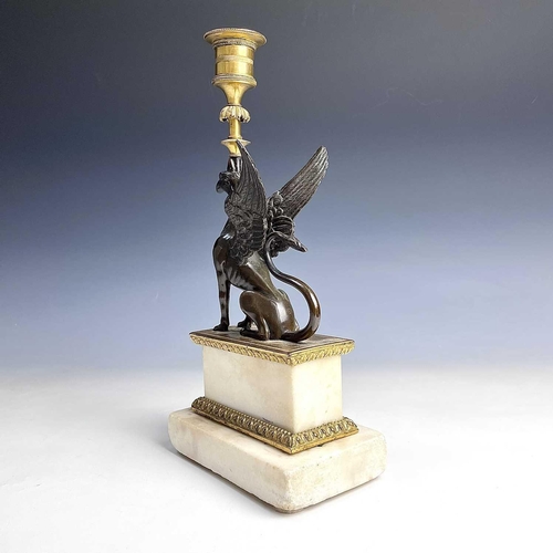 8 - A French bronze and ormolu candlestick, late 19th century, modelled as a winged griffin, on a steppe... 