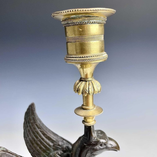 8 - A French bronze and ormolu candlestick, late 19th century, modelled as a winged griffin, on a steppe... 