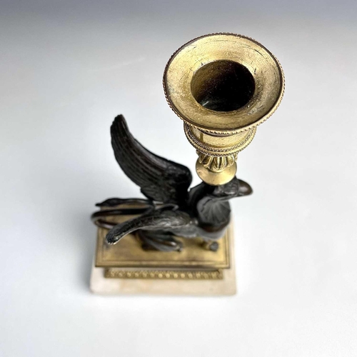 8 - A French bronze and ormolu candlestick, late 19th century, modelled as a winged griffin, on a steppe... 