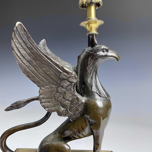 8 - A French bronze and ormolu candlestick, late 19th century, modelled as a winged griffin, on a steppe... 