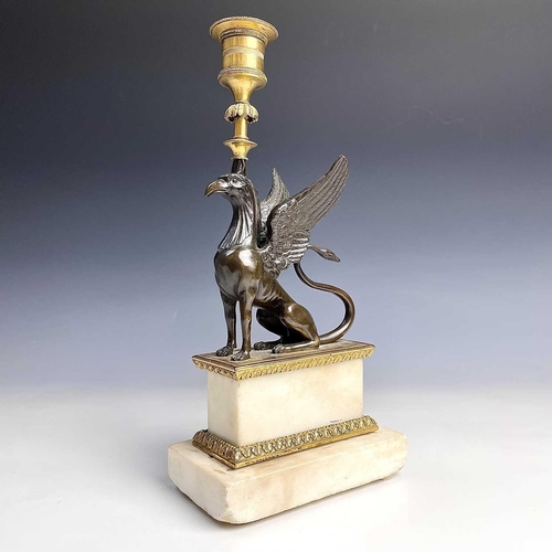 8 - A French bronze and ormolu candlestick, late 19th century, modelled as a winged griffin, on a steppe... 