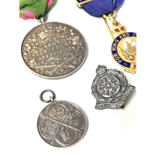 254 - Military and other Medals and Badges. A hallmarked silver Army Rifle Association medal, an A.C.C. 