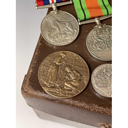 255 - World War Two Trio of Medals and various Horticultural Medallions. Lot comprises a small gas mask? b... 