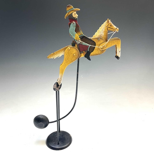 628 - Bucking Bronco Cowboy Automaton. A well painted pendulum operated seated cowboy with movable head, a... 