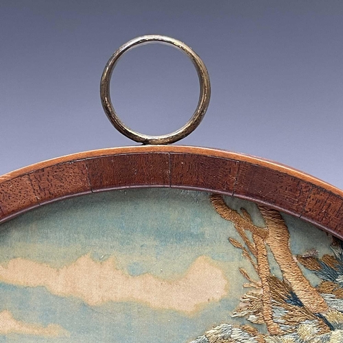 2803 - A Regency silk work oval picture of a shepherdess preparing a wreath, with painted detail, mahogany ... 