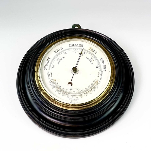 2907 - A late Victorian aneroid circular barometer, with white ceramic dial and ebonised case, diameter 28c... 