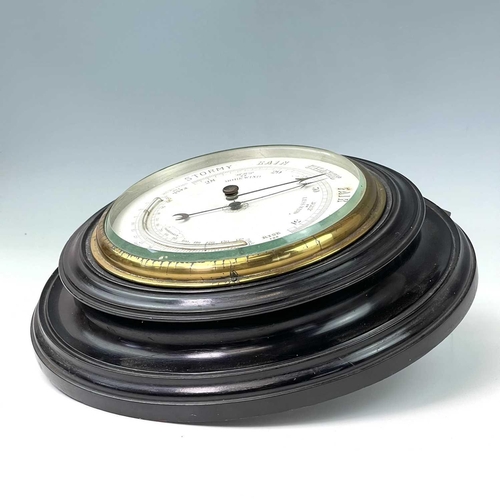 2907 - A late Victorian aneroid circular barometer, with white ceramic dial and ebonised case, diameter 28c... 