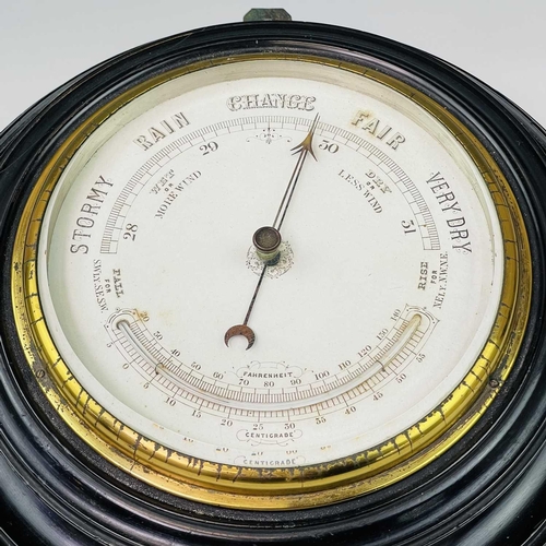 2907 - A late Victorian aneroid circular barometer, with white ceramic dial and ebonised case, diameter 28c... 