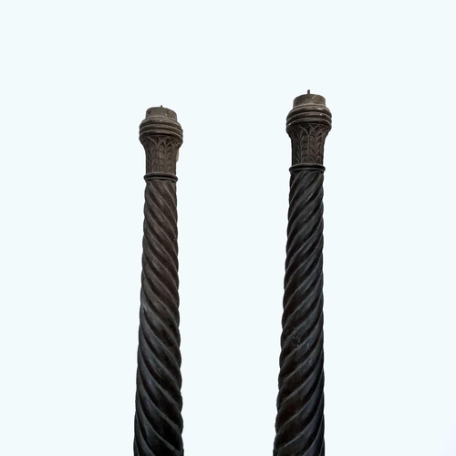 3001 - A pair of late George III mahogany bedposts, each with spiral turned, leaf carved and fluted decorat... 