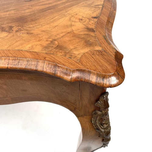 3004 - A Late Victorian walnut marquetry and brass mounted shaped table, the inlaid central decoration of s... 