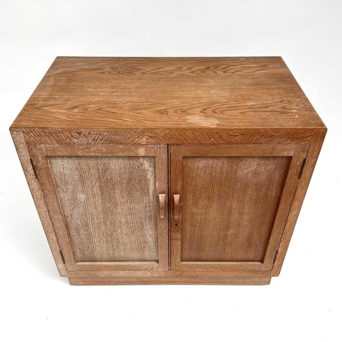 3008 - A Heal's type limed oak two door cupboard on castor wheels, signed and dated in pencil to interior R... 