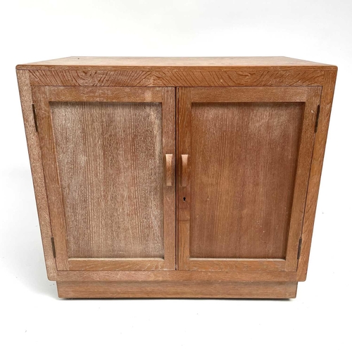 3008 - A Heal's type limed oak two door cupboard on castor wheels, signed and dated in pencil to interior R... 