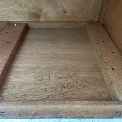 3008 - A Heal's type limed oak two door cupboard on castor wheels, signed and dated in pencil to interior R... 