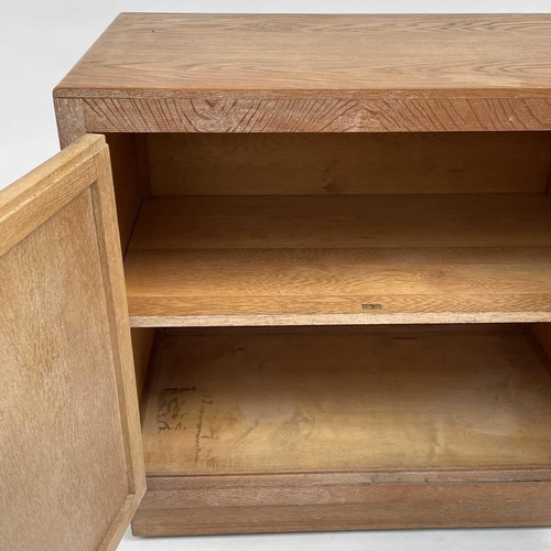 3008 - A Heal's type limed oak two door cupboard on castor wheels, signed and dated in pencil to interior R... 