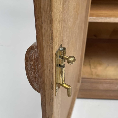 3008 - A Heal's type limed oak two door cupboard on castor wheels, signed and dated in pencil to interior R... 