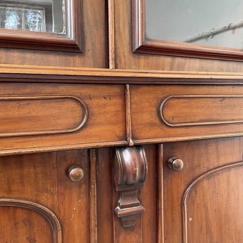 3010 - A Victorian mahogany bookcase with moulded cornice, glazed twin doors enclosing three adjustable she... 