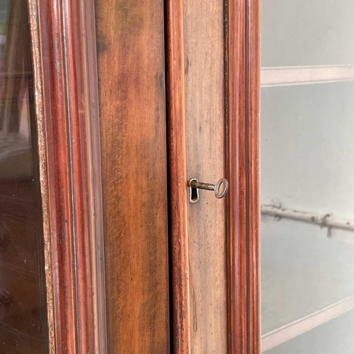 3010 - A Victorian mahogany bookcase with moulded cornice, glazed twin doors enclosing three adjustable she... 