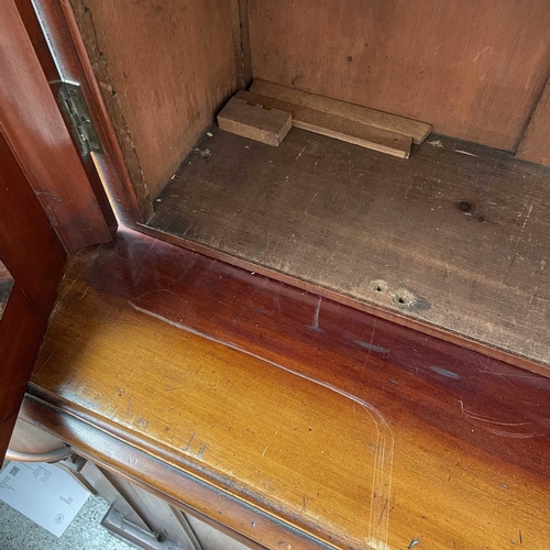 3010 - A Victorian mahogany bookcase with moulded cornice, glazed twin doors enclosing three adjustable she... 