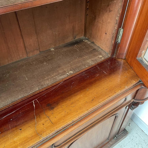 3010 - A Victorian mahogany bookcase with moulded cornice, glazed twin doors enclosing three adjustable she... 