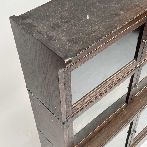 3020 - An oak sectional bookcase, 1930s, the three parts each with twin glazed hinged doors, height 119cm, ... 