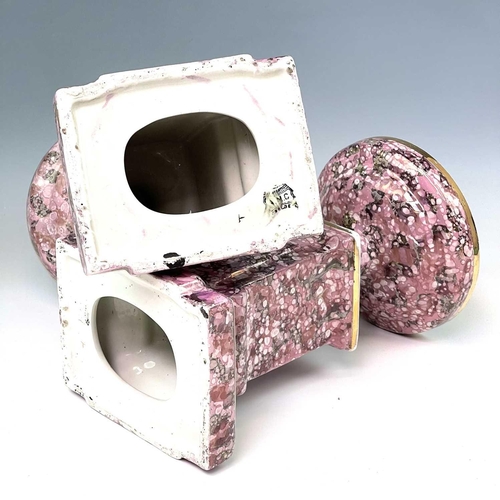 845 - A French pink lustre three-piece clock set, circa 1920, with mottled splash decoration, with two cla... 