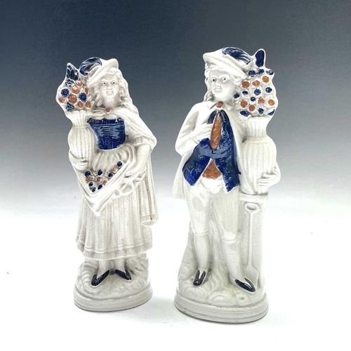 883 - A pair of Victorian Staffordshire flatback figures, of a young man and his companion, each beside a ... 