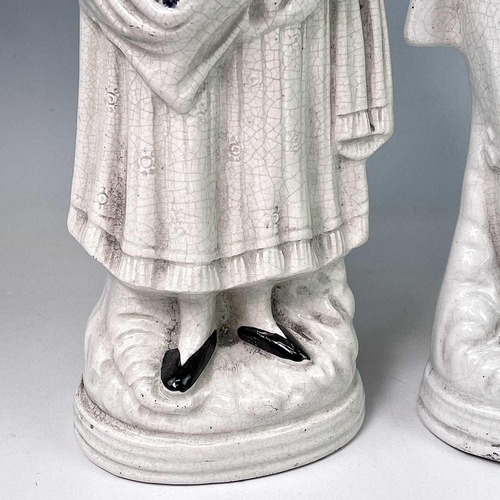883 - A pair of Victorian Staffordshire flatback figures, of a young man and his companion, each beside a ... 