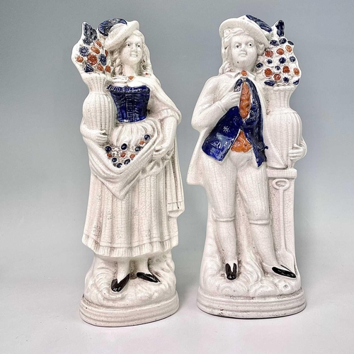883 - A pair of Victorian Staffordshire flatback figures, of a young man and his companion, each beside a ... 