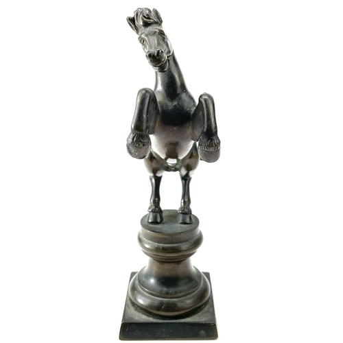 117 - A brass rearing stallion on a pedestal base, height 17cm.