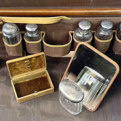 1611 - A late Victorian tan leather vanity case with a fitted interior including six silver topped toilet b... 