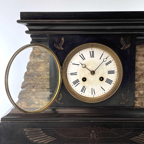 1704 - A French Egyptianesque black slate and marble mantle clock, circa 1890, with engraved motifs and flu... 