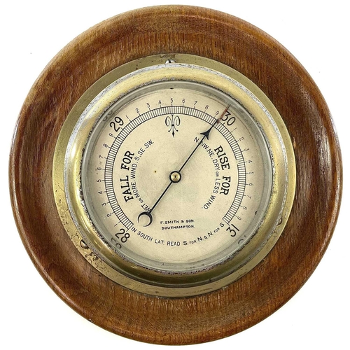 1714 - A brass marine aneroid barometer, the silvered dial stamped F.Smith & Son, Southampton, on an oak mo... 