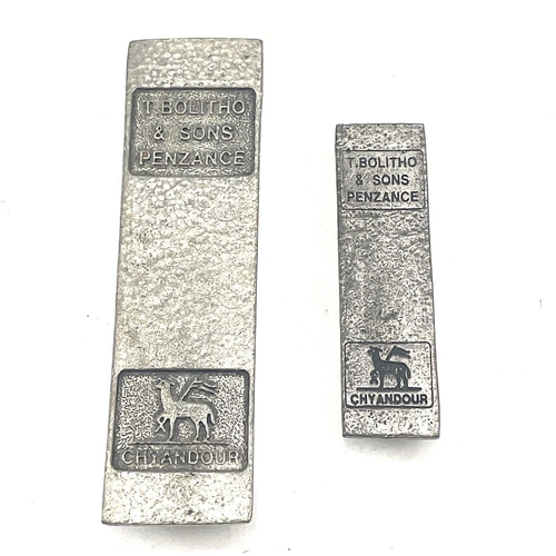 175 - Two miniture T. Bolitho & Sons Penzance copy tin ingots by St Justin, the largest 9 x 2.5cm.