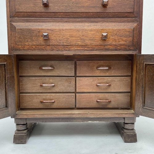 1811 - An Arts and Crafts oak bedroom cabinet, circa 1930, in the Cotswolds taste, fitted with two long dra... 