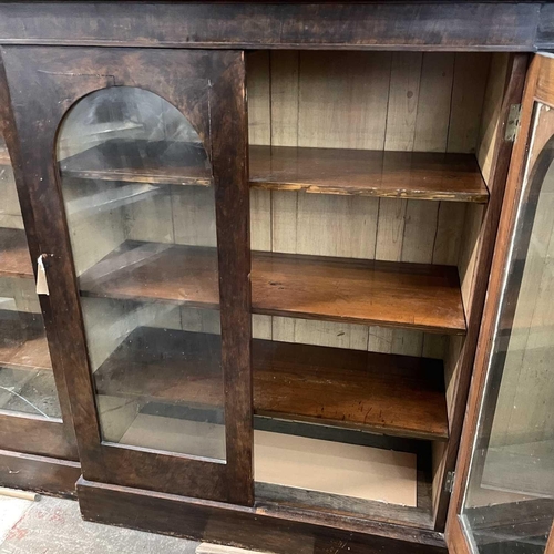 1814 - A Victorian mahogany breakfront low bookcase, the four glazed doors with arched tops, on a plinth ba... 