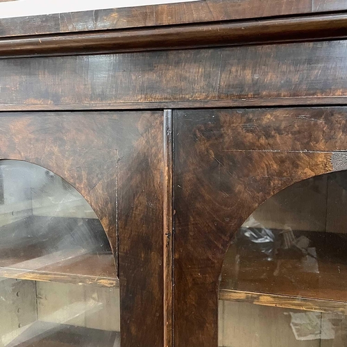 1814 - A Victorian mahogany breakfront low bookcase, the four glazed doors with arched tops, on a plinth ba... 