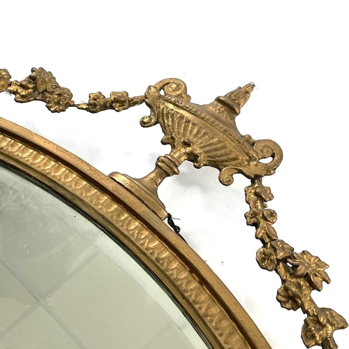 1823 - An Edwardian gilt framed oval wall mirror, of Neo-Classical form, with urn and festoon cresting, hei... 