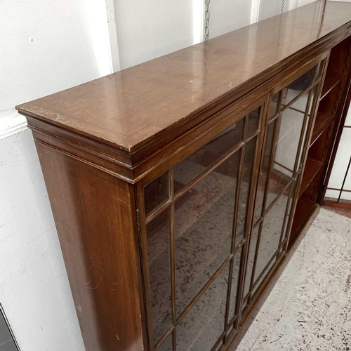 1834 - An Edwardian walnut bookcase, with triple glazed doors enclosing adjustable shelves on a plinth base... 