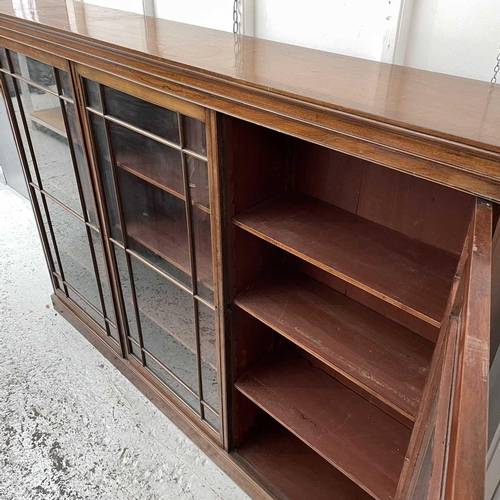 1834 - An Edwardian walnut bookcase, with triple glazed doors enclosing adjustable shelves on a plinth base... 