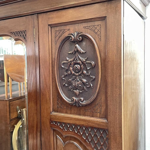 1858 - A late Victorian walnut triple wardrobe, with floral carved and mirrored panels enclosing hanging sp... 