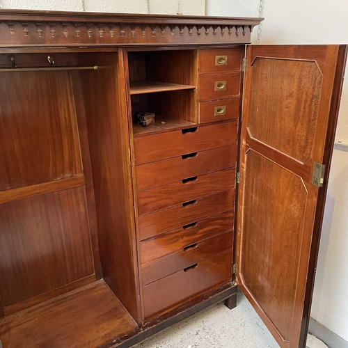 1876 - A 19th century mahogany wardrobe, with arcaded cornice above two panel doors, one enclosing hanging ... 