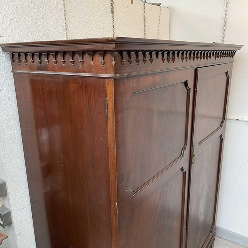 1876 - A 19th century mahogany wardrobe, with arcaded cornice above two panel doors, one enclosing hanging ... 