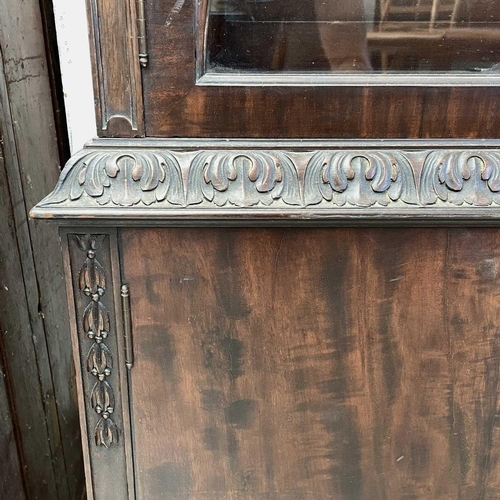 1882 - A George III style mahogany bookcase cabinet, circa 1900, with fluted frieze above two glazed doors,... 