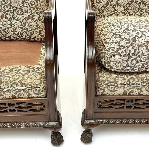 1896 - A walnut framed three piece Bergere suite, circa 1920, with loose cushions on carved ball and claw f... 