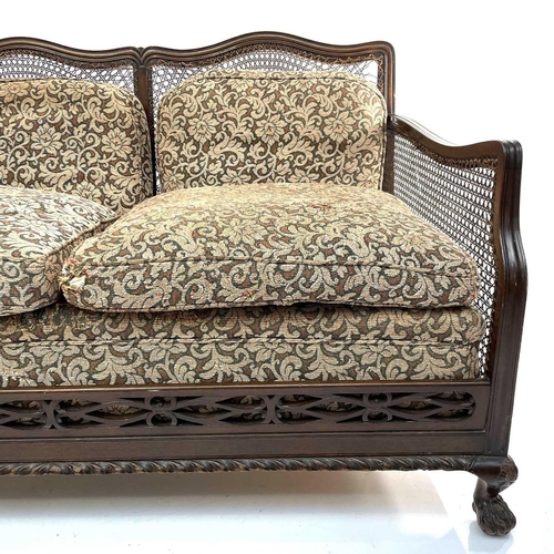 1896 - A walnut framed three piece Bergere suite, circa 1920, with loose cushions on carved ball and claw f... 