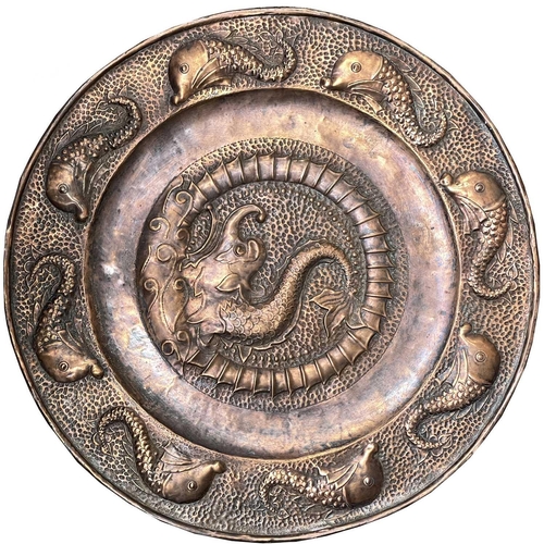 19 - A J.&F.Pool, Hayle copper charger, repousse decorated with a central dolphin, with further dolphins ... 