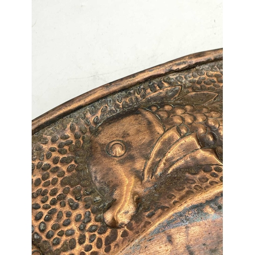 19 - A J.&F.Pool, Hayle copper charger, repousse decorated with a central dolphin, with further dolphins ... 