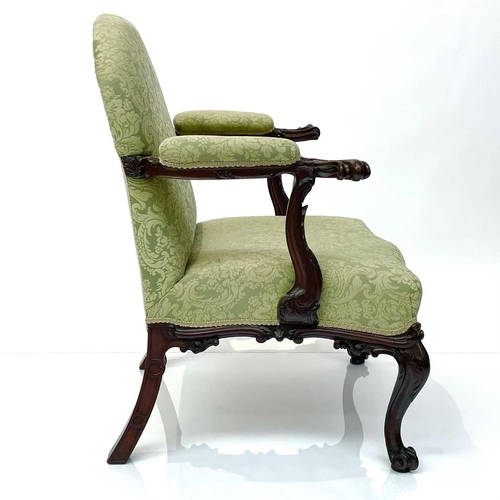 1910 - A George III mahogany Gainsborough type open armchair, the padded arms with prominent moulded outswe... 