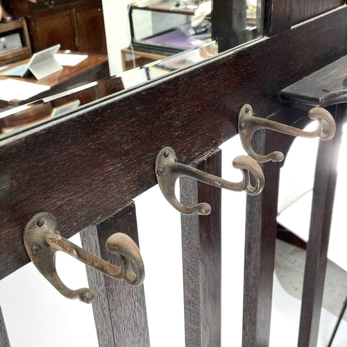 1913 - An oak hallstand, with central mirror and incorporating two stick stands, height 187cm, width 100cm,... 